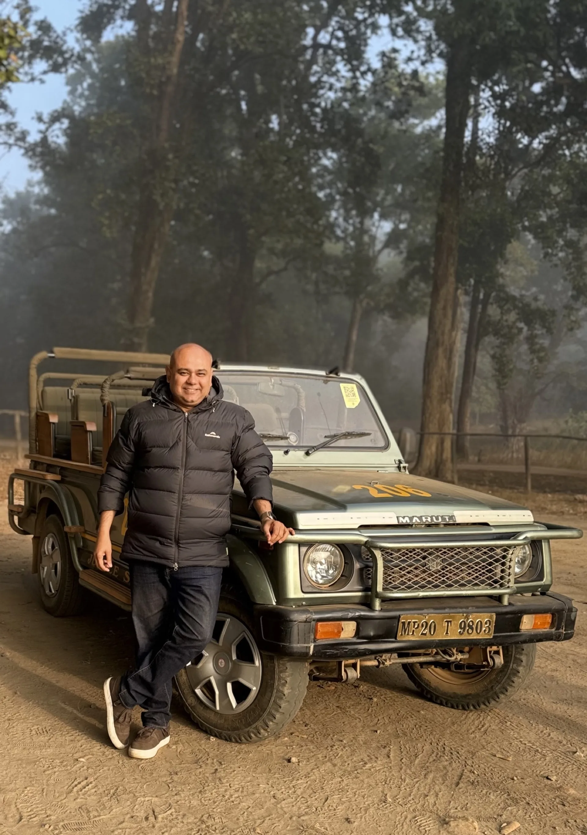 Krishna, founder of Junglee Wildlife Tours, standing with a safari jeep at Kanha National Park, India